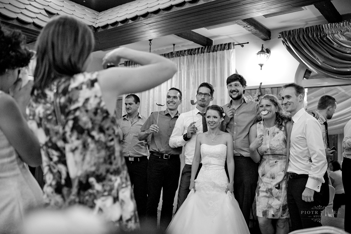 fotografia ślubna gliwice - Goście weselni wraz z młodą parą robią wspólne zdjęcia