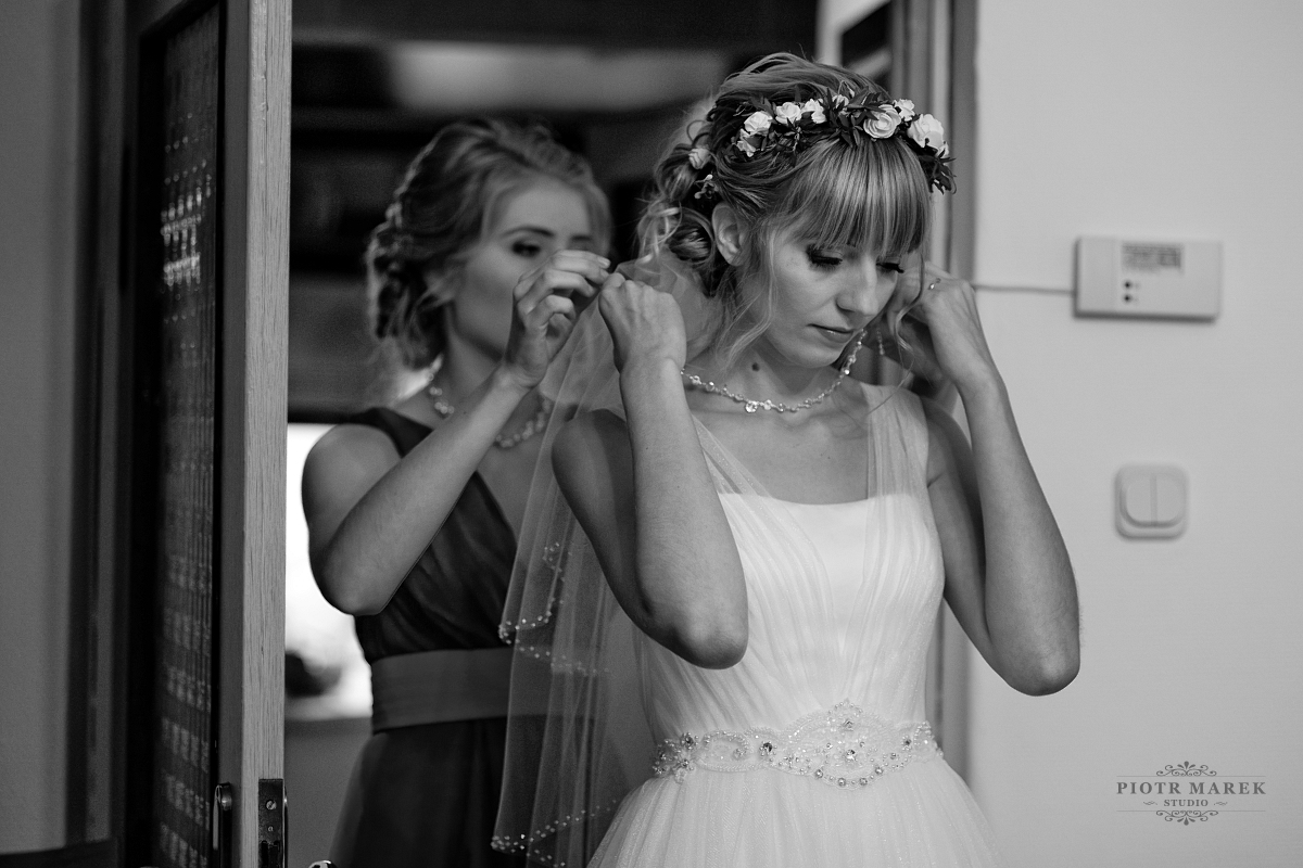fotografia ślubna katowice - Pani mloda zakłada naszyjnik
