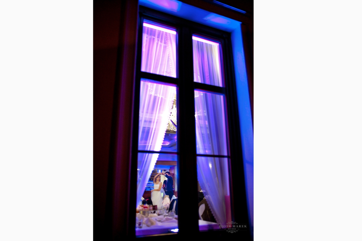 fotografia ślubna sosnowiec - W oddali widać tańczącą młodą parę