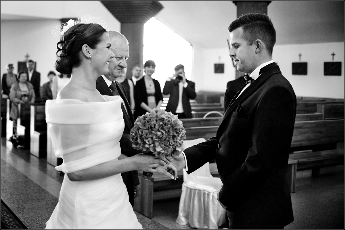 fotografia ślubna gliwice - Młoda para wita się przy ołtarzu