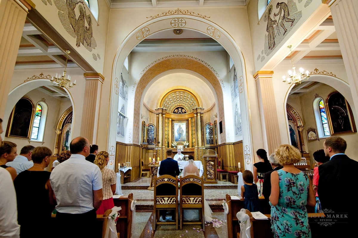 fotograf ślubny rybnik - Młoda para stoi przed ołtarzem
