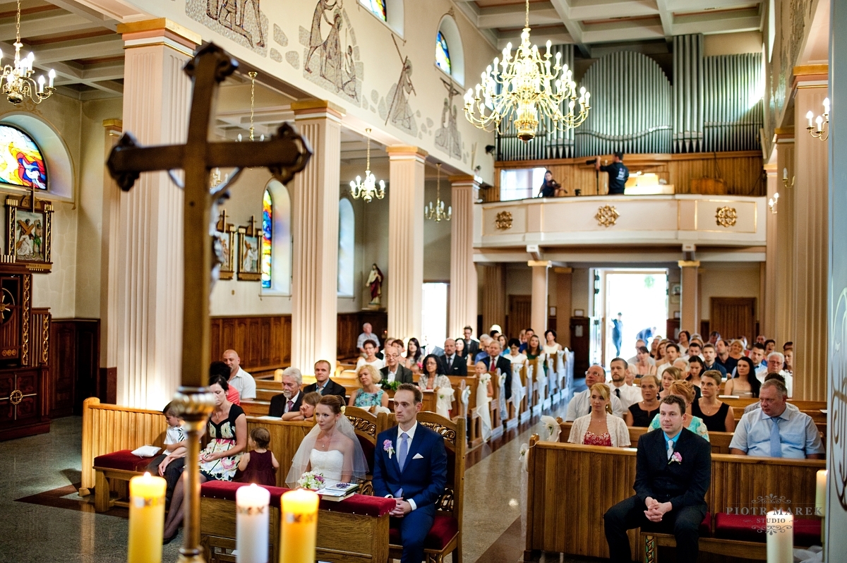 fotograf ślubny rybnik - Młoda para siedzi przed ołtarzem