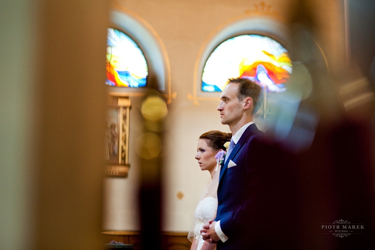 fotograf ślubny rybnik - Młoda para stoi przed ołtarzem