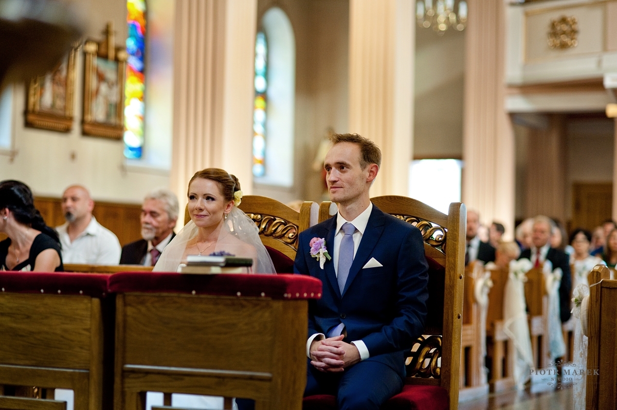 fotograf ślubny rybnik - Młoda para siedzi przed ołtarzem